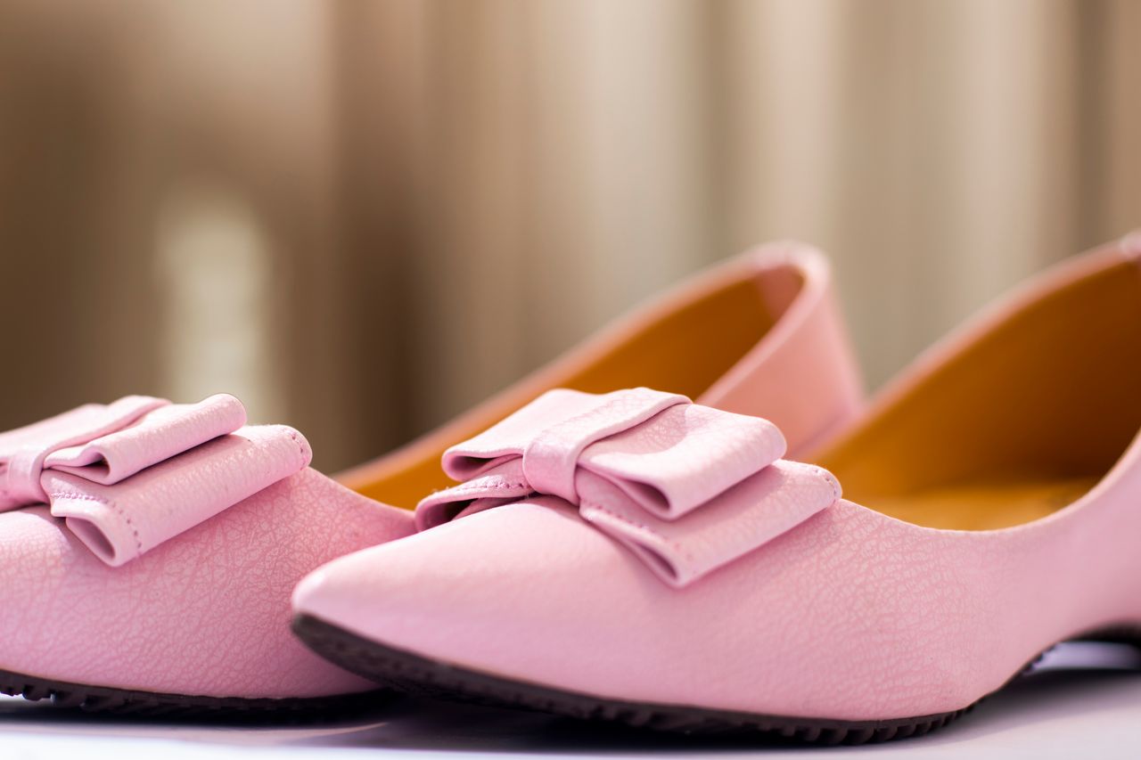 Elegant pink leather shoes with decorative bows in a fashionable close-up shot.